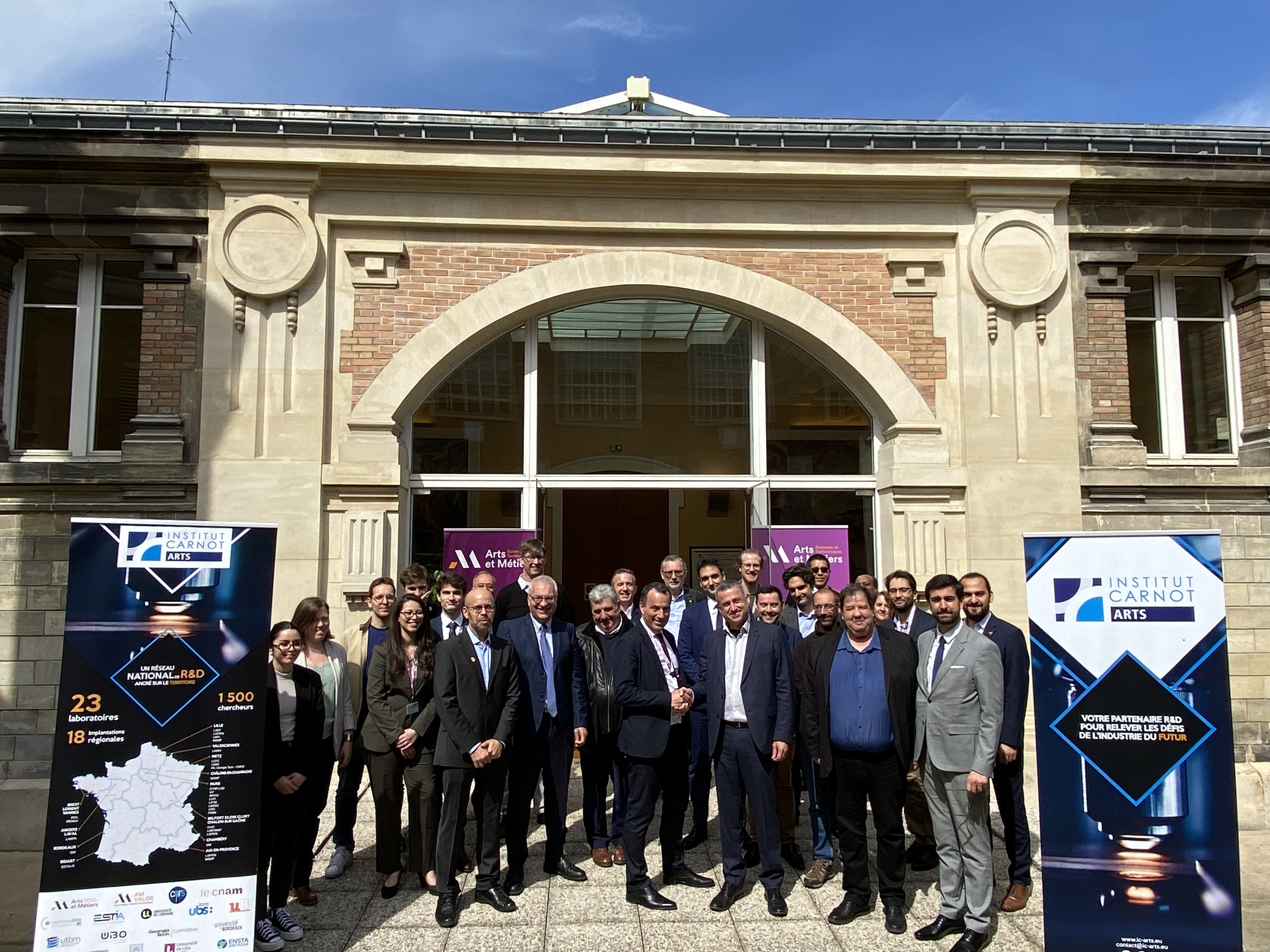 Photo de groupe, Laurent Champaney (Arts et Métiers), Jérôme Bonini (Safran AE) et le personnel du laboratoire LIFSE devant la bibliothèque d'Arts et Métiers