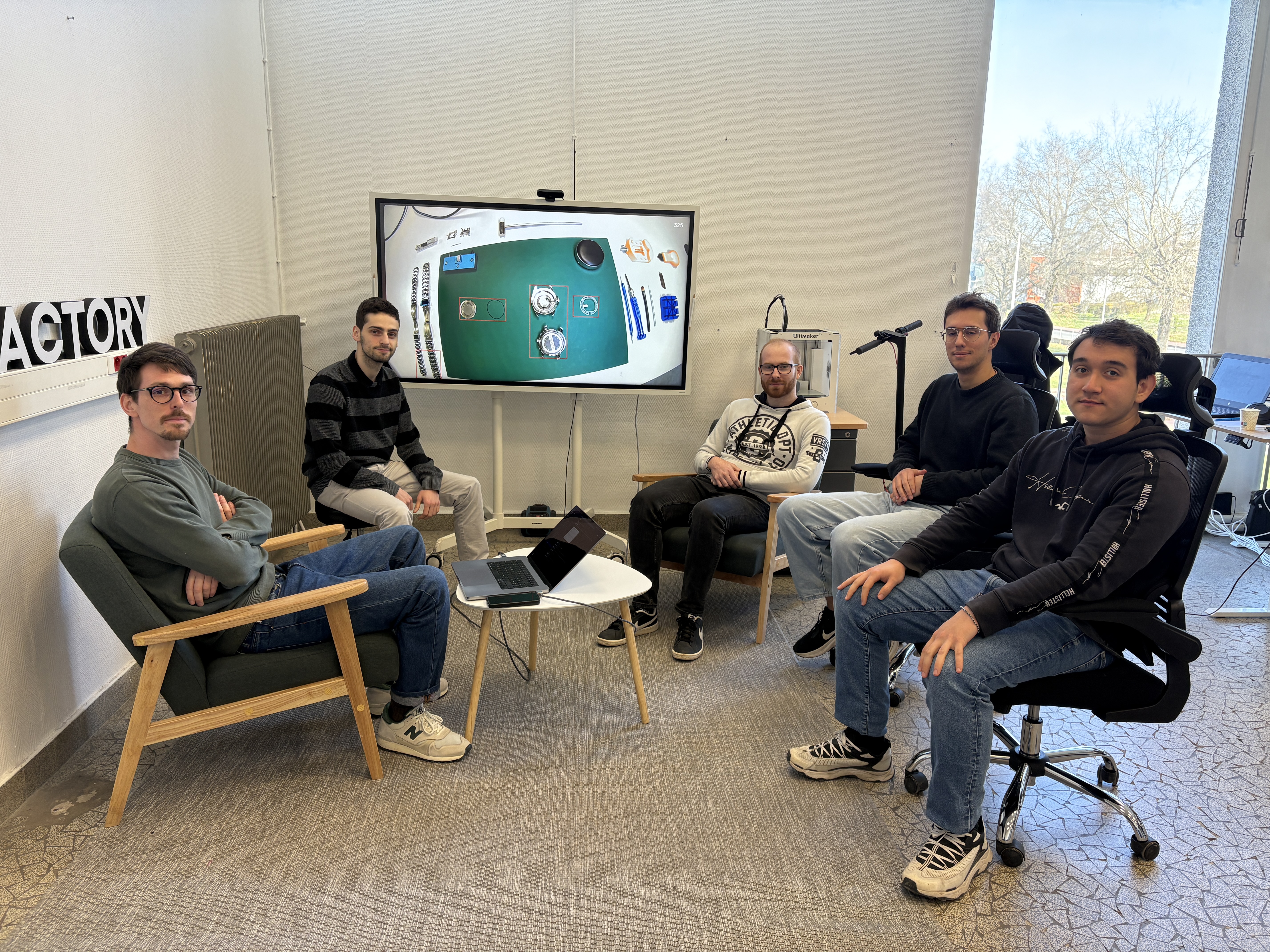 réunion avec 5 hommes autour d'une table et d'un ordinateur