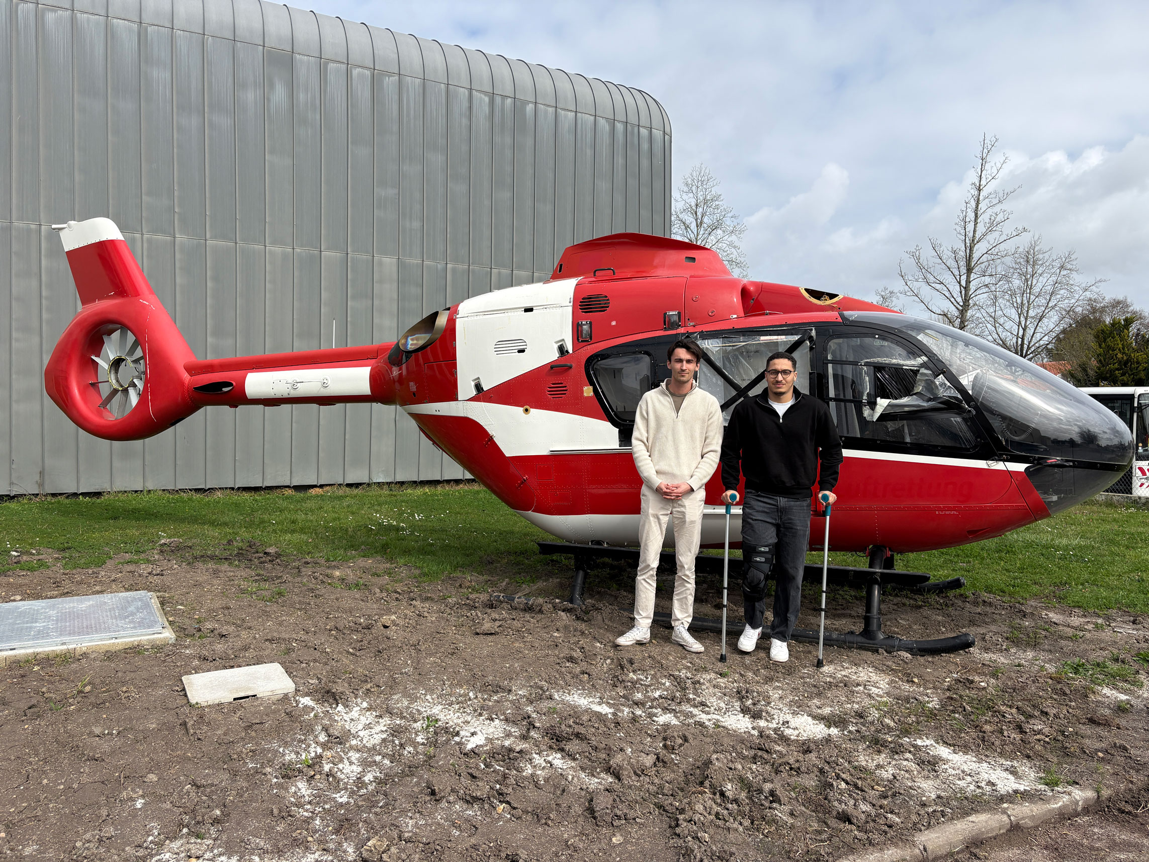 Two men in front of a helicopter