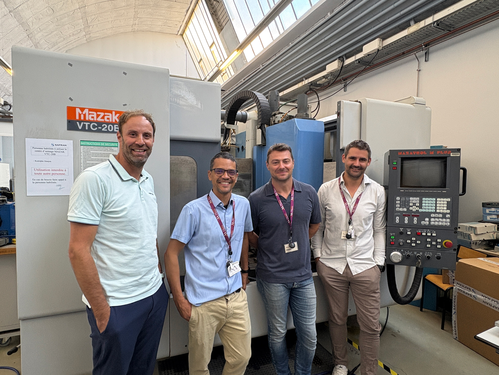 4 hommes devant une machine