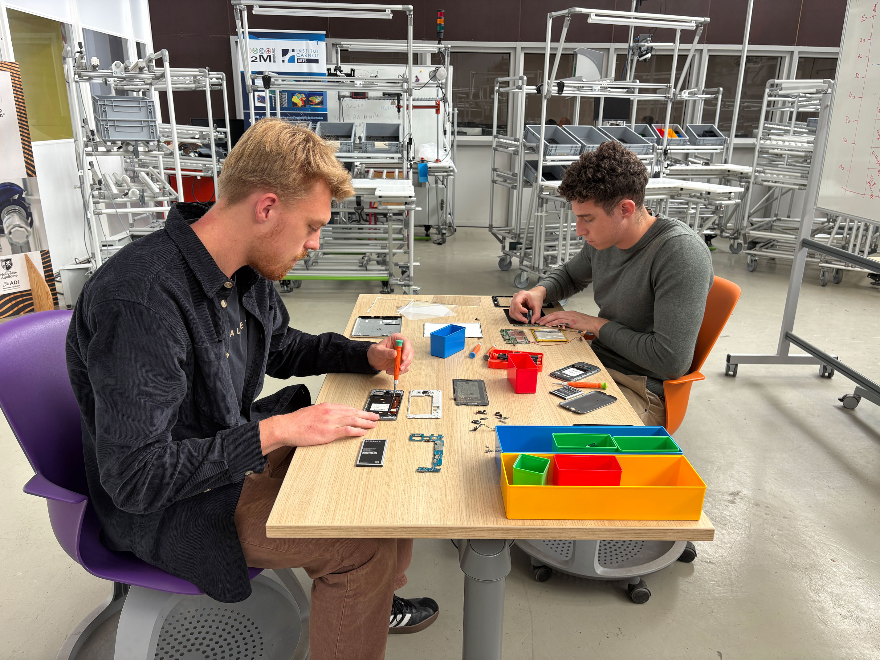 deux hommes qui démantèlent un téléphone portable