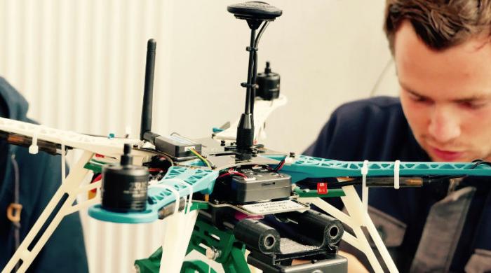 Visuel présentant des étudiants en pleine conception d'un drone aux rotors apparents