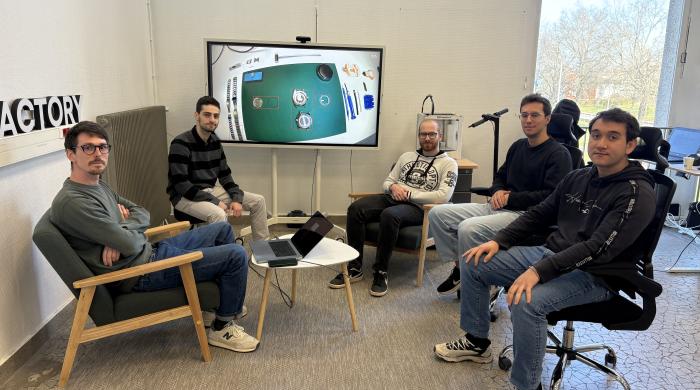meeting with five men around a table and a computer