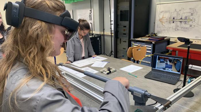 young woman wearing an extended reality headset while working 