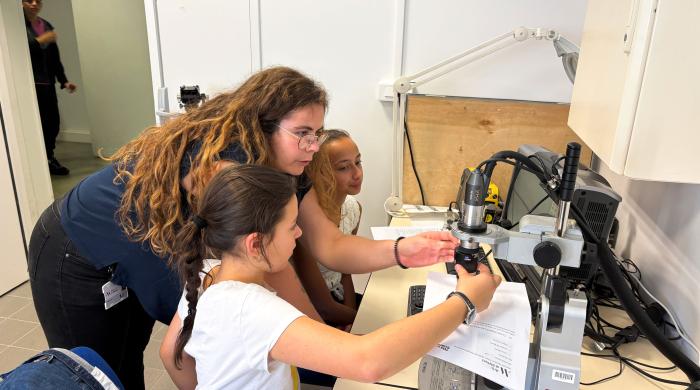 scientifique avec deux enfants regardant un microscope
