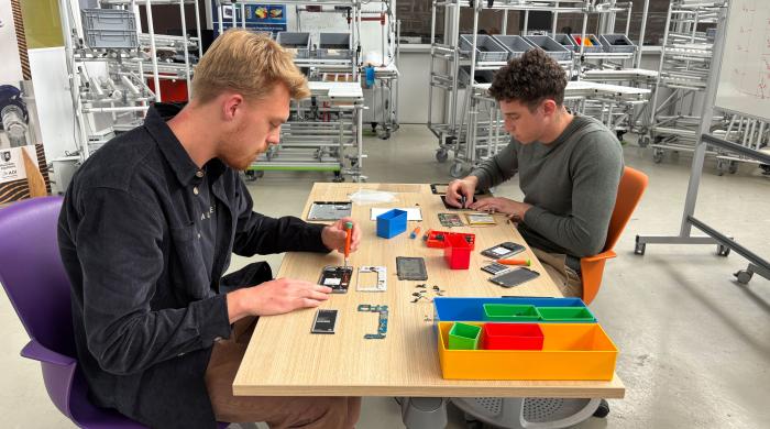 deux hommes qui démantèlent un téléphone portable